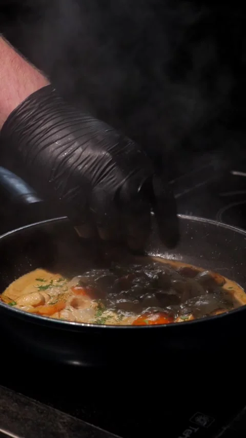 Man fries vegetables and meat in sauce, sprinkles with herbs and stirs Stock Footage 309463512