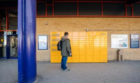 Man in front of Amazon Locker at the Oxford Train Station receiving parcel Foto stock
