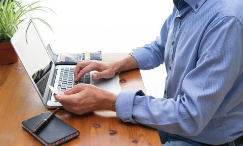 Man in front of computer paying online. Stock Photos