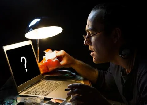 The man in front of a computer screen at night Stock Photos