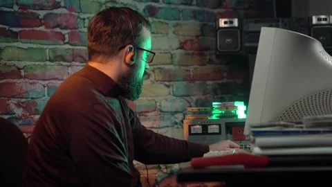 Man in Front of Desktop Computer From 1980s Starts Playing Music on Vintage Stock Footage 305821600