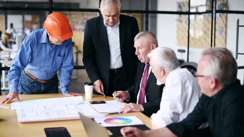 Man in front laughs hard. Aged team of elderly businessman architects Stock Footage 304870625