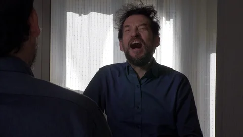 Man in front of mirror laughing about crazy hair Stock Footage 126404286