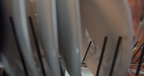 A man in front of an open dishwasher takes out or puts down dishes. Stock Footage 264584976