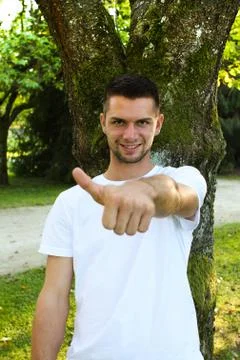 Man in front of a tree with thumb up Stock Photos