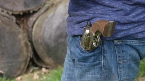 Man in front of wooded backdrop has vintage gun revolver in Jeans Stock Footage 153293111
