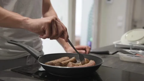 Man frying meat in the kitchen. Stock Footage 134943408