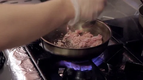 Man frying meat standing in kitchen indoors Stock Footage 76028009