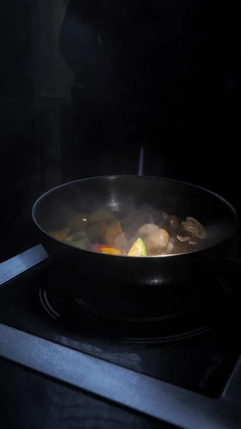 Man frying vegetables and meat in sauce, throwing in a frying pan. Chef cooking Stock Footage 309463446
