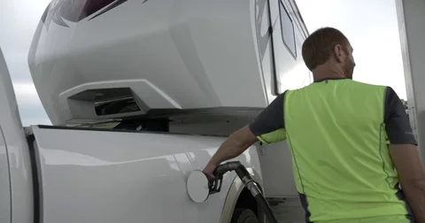 Man Fuels in Truck Pulling a 5th Wheel Toy Hauler Stock Footage 81456269