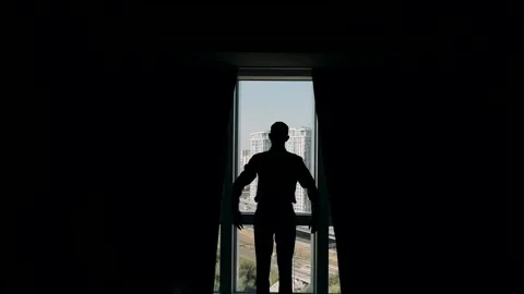 Man in full growth, standing in backlight with his back to the camera, opens t Stock Footage 309498299