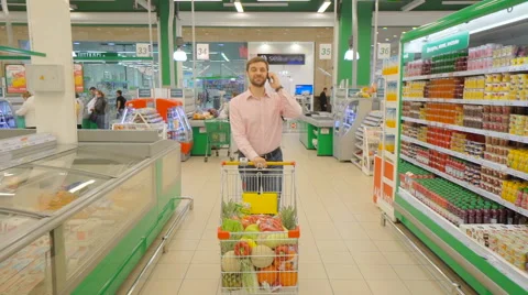 Man with full supermarket trolley Stock Footage 63372576
