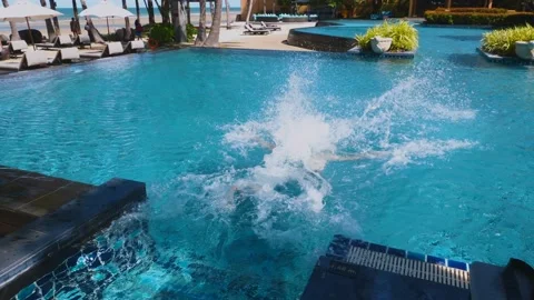 Man fun and jumps into pool with big splashes at luxury hotel Video stock 231544725