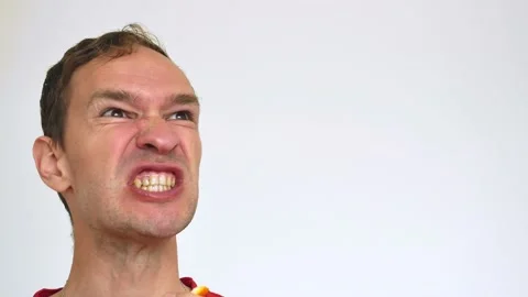 Man Funny eats an orange on a white background Stock Footage 133138055