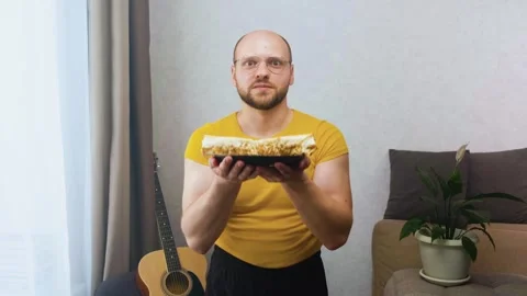 A man with a funny facial expression picks up a plate of burrito food Stock Footage 243758443
