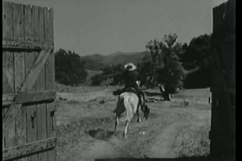 Man on galloping horse riding through wooden gate 스톡 동영상 14521782