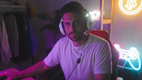 Man with gaming headset at computer shows middle finger to camera in studio.. Stock Footage 347725251