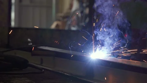 A man in the garage cooks a frame with the help of a welding machine. Stock Footage 153771136