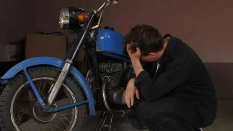 Man in a garage looking stressed and frustrated with his hands on his head Stock Footage 342765369