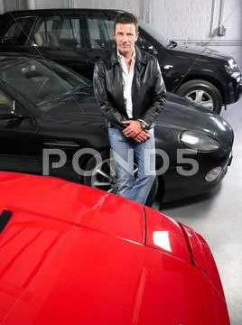 Man In Garage With Luxury Cars.