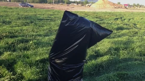 Man in garbage bag jumping Stock Footage 61135493
