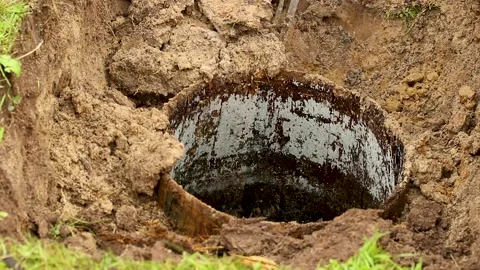 A man in a garden plot dismantles an old well, Stock Footage 169650491