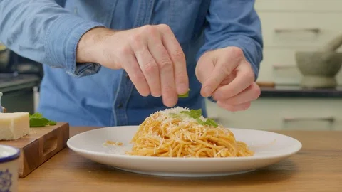 Man Garnishing Spaghetti With Basil On Plate In Kitchen Stock Footage 86075433