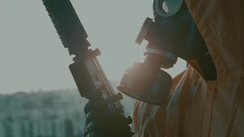 A man in a gas mask, a protective suit, with a weapon in his hand close-up. Stock Footage 160220122