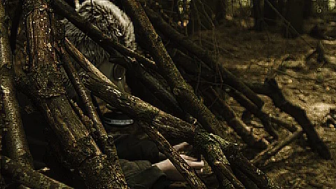A man with a gas mask on sitting inside a small makeshift hut. Side view Video stock 89407505