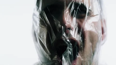 Man gasping for air under suffocating plastic bag in polluted world 動画素材 312474626