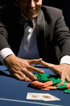 Man gathering his chips after a gambling win Photos