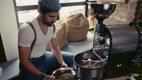 Man gathering roasted coffee beans from the roasting machine Stock Footage 95911467