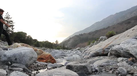 Man gazes at rocky mountain stream 動画素材 52000661