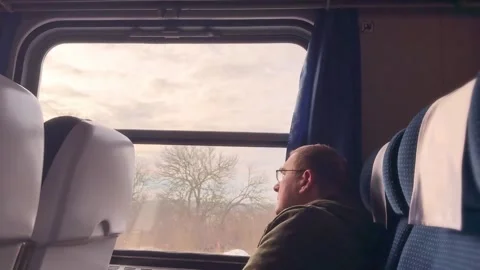 Man Gazing Out Train Window During Winter Scenic Journey Stock Footage 297702499