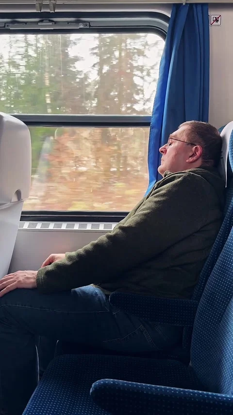 Man Gazing Out Train Window During Winter Scenic Journey Stockbeeldmateriaal 297703014