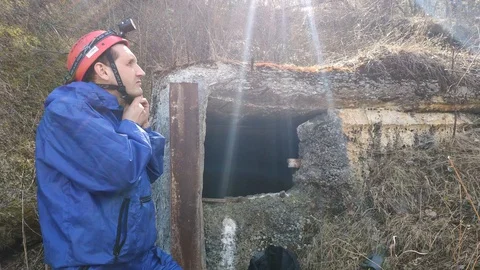 A man in gear with a flashlight puts on his helmet. Stock Footage 129394878
