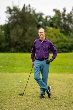 Man in a generic golf pose with leg crossed at ankle Stockfoto's