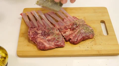 A man generously sprinkles spices on fresh beef before cooking. He carefully Stock-Footage 270442863
