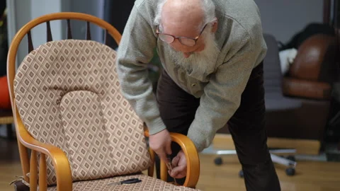 Man Gently Adjusting His Rocking Chair in a Comfortable and Cozy Environment Stock Footage 292841438
