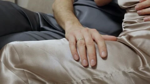 Man gently caressing womans leg in satin dress Video stock 310037706