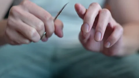 Man is gently grooming nails using scissors, showcasing meticulous attention to Stockbeeldmateriaal 337111394