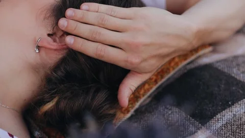 The man gently holds behind the ear stroking his girlfriend on the head Stock Footage 250484893