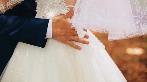 The man gently runs his hand over the dress of his beloved. Close up. Stock Footage 120073494