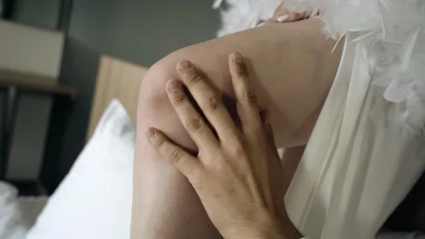A man gently runs his hand down his girlfriend's leg. Close-up shooting. Stock Footage 316705434