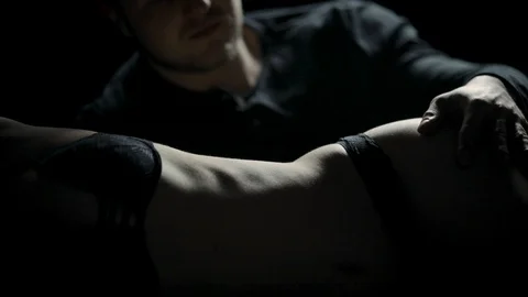 A man gently runs his hands over a woman's body in the dark Video stock 104640166
