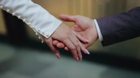 The man gently takes his beloved's hand. The lovers' hands are taken in close-up Stock Footage 294343890