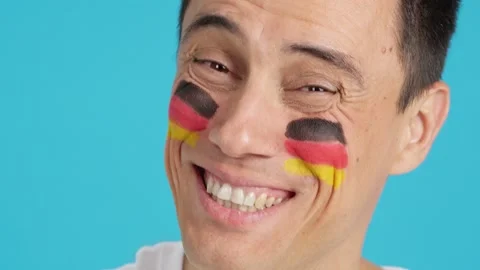 Man with a german flag painted on the face smiling 動画素材 252484886