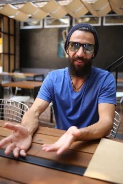 Man gesticulate with hands in cafe Stock Photos
