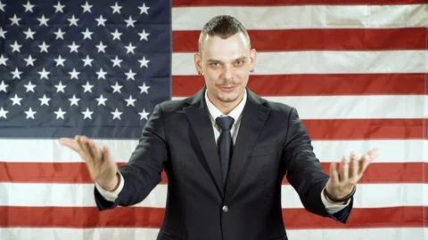 Man gesticulating and speaking against the background of the American flag. Stock Footage 119570143