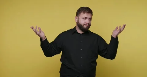 Man gestures with hands in front of yellow background during a communicatio.. 스톡 동영상 326789662